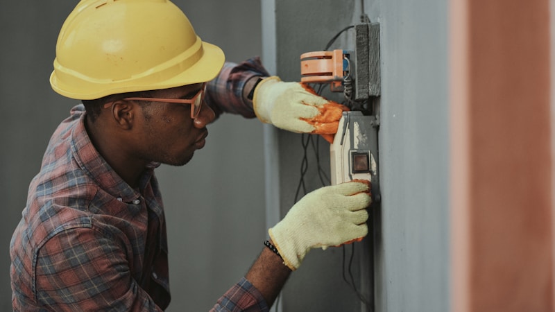 Elettricista al lavoro su quadro elettrico a Como